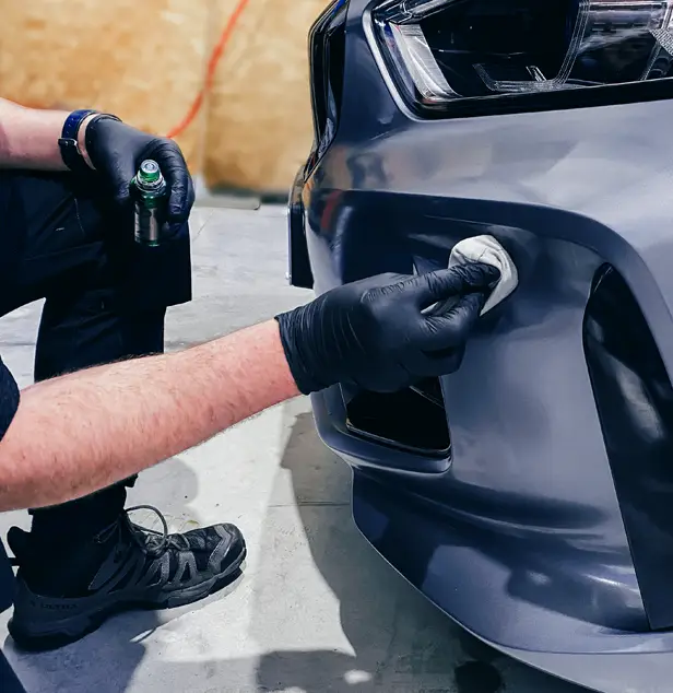 Technicien JP Wash appliquant un traitement céramique sur la carrosserie d’un véhicule lors d’un soin Thalasso Car.