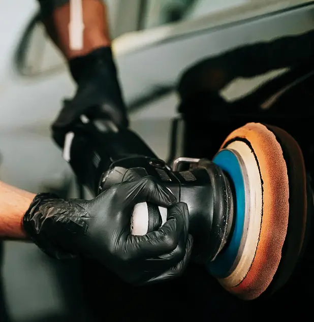 Polissage de carrosserie réalisé à la machine chez JP Wash pour corriger les micro-rayures du véhicule.